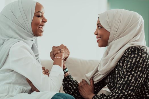 African women arm wrestling conflict concept, disagreement, and confrontation wearing traditional Islamic hijab clothes. Selective focus. High-quality photo