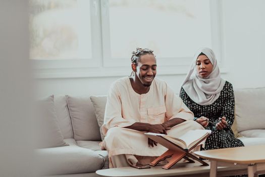 African Muslim couple at home in Ramadan reading Quran holly Islam book. High-quality photo