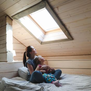 Portrait of enjoy happy family mother and little girl hugging, smiling, playing and having good time in a cozy room at home