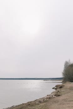 The incredible view of river or lake in spring. Blue water surface with small waves under blue sky.