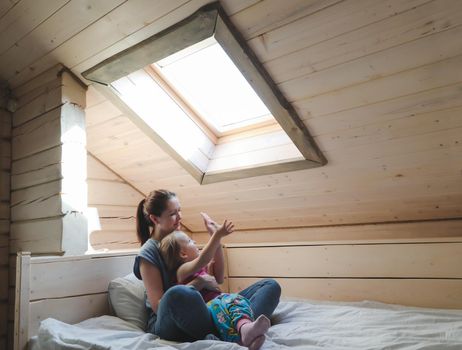 Portrait of enjoy happy family mother and little girl hugging, smiling, playing and having good time in a cozy room at home