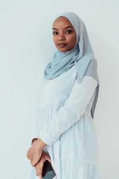 An African Muslim woman using a smartphone on a white background. High-quality photo