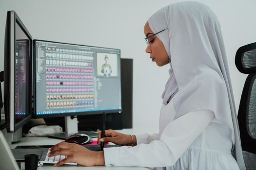 Young Afro-American modern Muslim businesswoman wearing a scarf in a creative bright office workplace with a big screen. High-quality photo