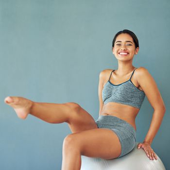 Shot of a sporty young woman sitting on a swiss ball.