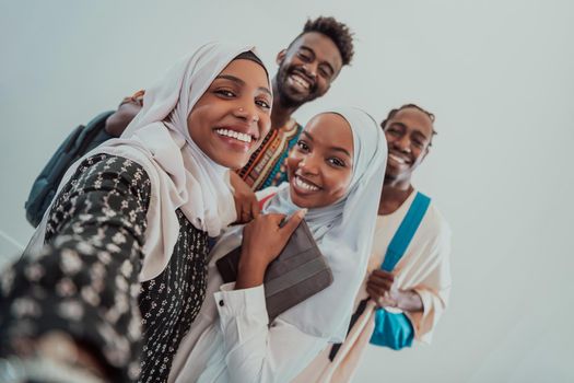A group of multiethnic students takes a selfie with a smartphone on a white background. Selective focus . High-quality photo
