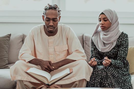 African Muslim couple at home in Ramadan reading Quran holly Islam book. High-quality photo