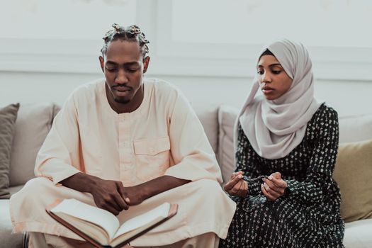 African Muslim couple at home in Ramadan reading Quran holly Islam book. High-quality photo