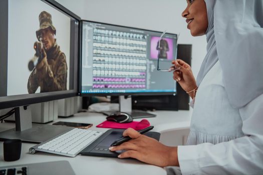 Young Afro-American modern Muslim businesswoman wearing a scarf in a creative bright office workplace with a big screen. High-quality photo