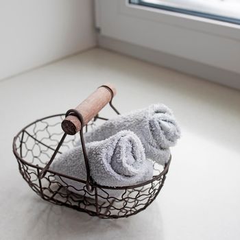 rolled towels in metal basket at clean bathroom. Square frame