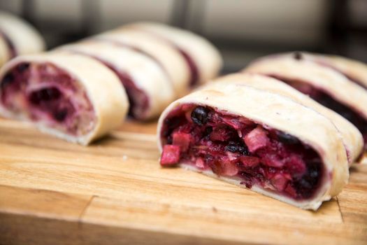 Fresh pastries - cherry, apple and walnut strudel arranged in a row at a morning coffee banquet