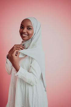 Portrait of young modern muslim afro beauty wearing traditional islamic clothes on plastic pink background. Selective focus. High quality photo