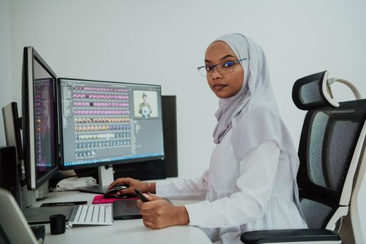 Young Afro-American modern Muslim businesswoman wearing a scarf in a creative bright office workplace with a big screen. High-quality photo