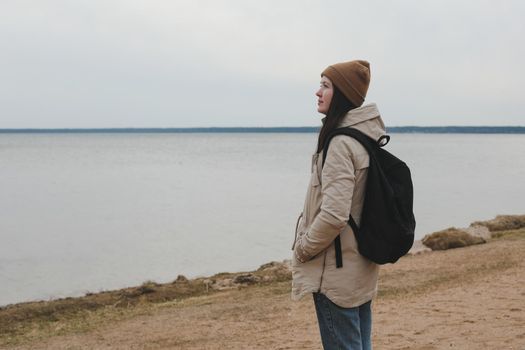 Portrait of young woman in a hat looking over the sea or the ocean, enjoying amazing nature, feeling of freedom. Female traveler