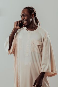 African man using smartphone and wearing traditional Sudan clothes. High-quality photo