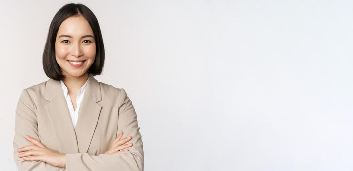 Confident female entrepreneur, asian business woman standing in power pose, professional business person, cross arms on chest, standing over white background.