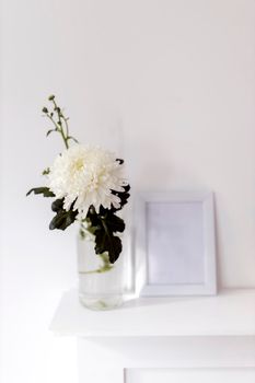 Large chrysanthemum in a glass vase. Photo frame with place for text, Office decoration. Copy space. Place for text