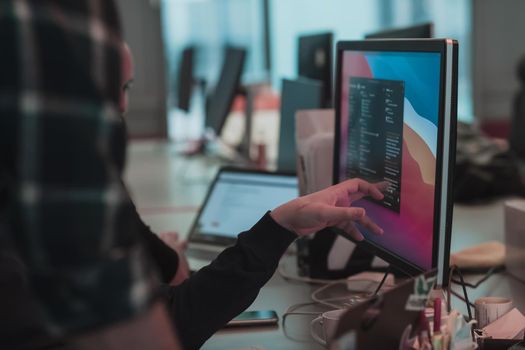 A photo of three men staring intently at a computer while sitting in a modern office. Selective focus. High-quality photo