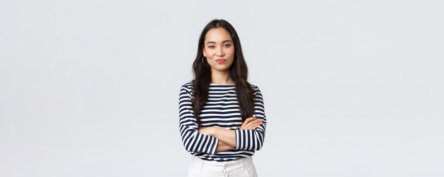 Lifestyle, beauty and fashion, people emotions concept. Skeptical and judgemental asian female office manager looking picky, smirk and pouting dissatisfied, cross arms chest.