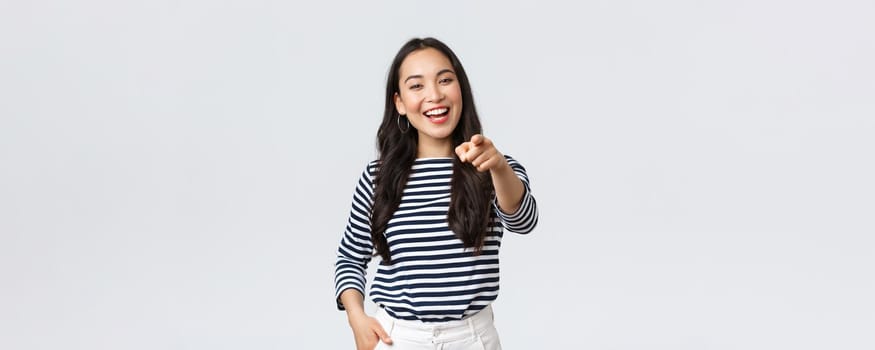 Lifestyle, beauty and fashion, people emotions concept. Happy cheerful asian girl praising you, picking person, found excellent employee for job position, pointing camera and smiling.