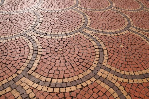 brown paving stones laid out in circles, perspective view