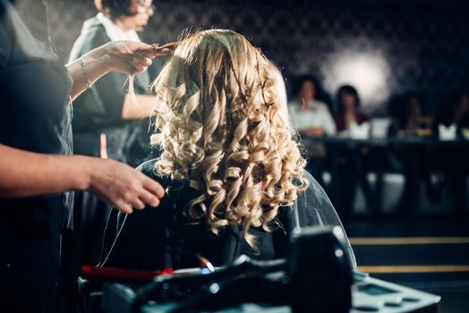 Master stylist makes the bride wedding hairstyle using spray lacquer fixing,