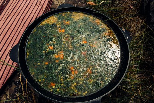 Russian soup, borsch, in a cast iron pot on the background of rye bread, on a wooden table in a stylish restaurant, in the old Russian style,