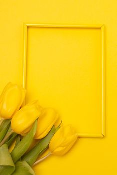 Tulips and a frame on a yellow background . Tulips of kopi space. Yellow background. Mockup . Space for text. A greeting card. Tulips on a yellow background. Spring flowers. March eighth. Mother's Day. Birthday