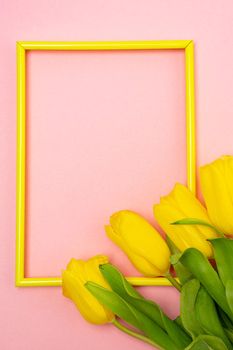 Tulips and a frame on a pink background . Tulips of kopi space. Pink background. Mockup . Space for text. A greeting card. Tulips on a pink background. Spring flowers. March eighth. Mother's Day. Birthday