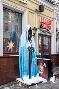 Moscow, Russia - 20 December 2021, Two skeletons in a red and blue Santa Claus fur coat stand on both sides at the entrance to the Wild Coyote cafe