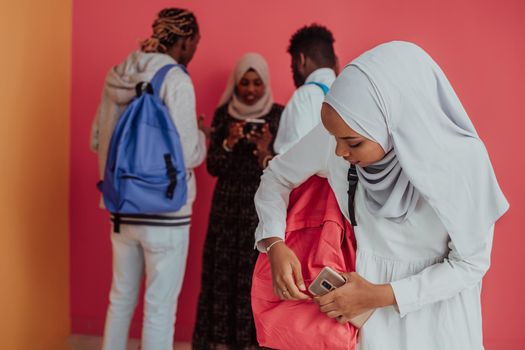 A group of African Muslim students with backpacks posing on a pink background. the concept of school education. High-quality photo