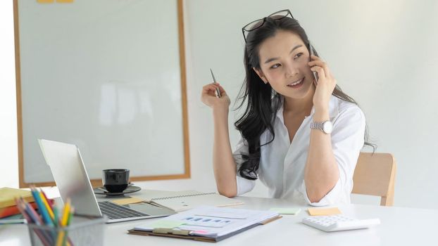 female entrepreneur sitting in portable workspace during call consulting.