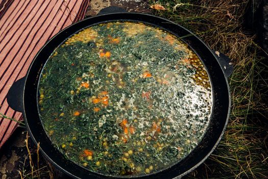 Russian soup, borsch, in a cast iron pot on the background of rye bread, on a wooden table in a stylish restaurant, in the old Russian style,