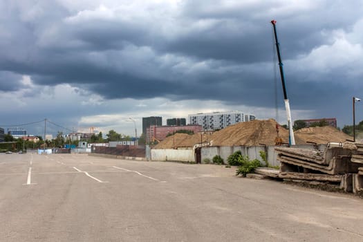 Moscow, Russia - 07 June 2021, Long factory pipes lie on the ground against the backdrop of a residential area under construction