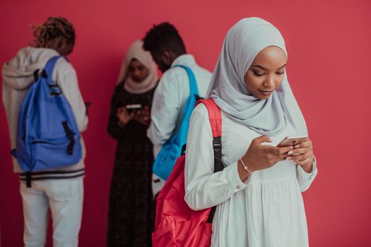 A group of African Muslim students with backpacks posing on a pink background. the concept of school education. High-quality photo