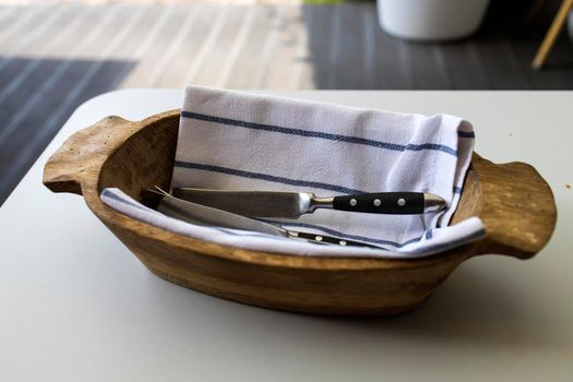 Wooden bowl with a towel inside for cutlery served in the restaurant