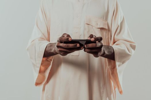 African man using smartphone and wearing traditional Sudan clothes. High-quality photo