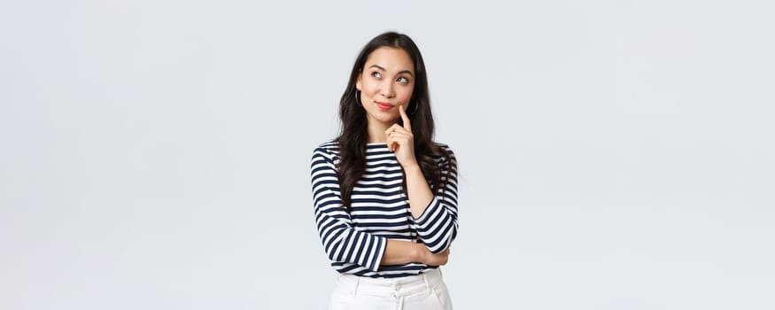 Lifestyle, people emotions and casual concept. Thoughtful stylish young woman smiling pleased, dreaming or imaging perfect plan, have interesting idea, thinking and looking upper left corner.
