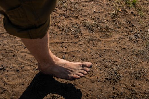 Men's feet with blue socks and campfire rests. Hiking, campground concept.