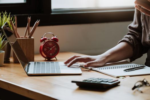 Business woman at working with financial reports and laptop computer in the office