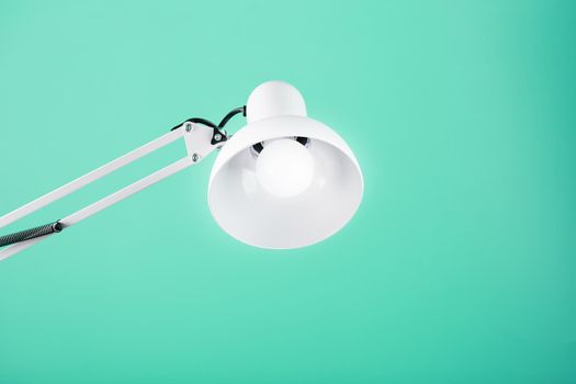 White table office lamp on green background with space for text and idea concept