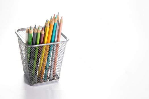 Colored pencils in an iron pencil case isolated on a white background.