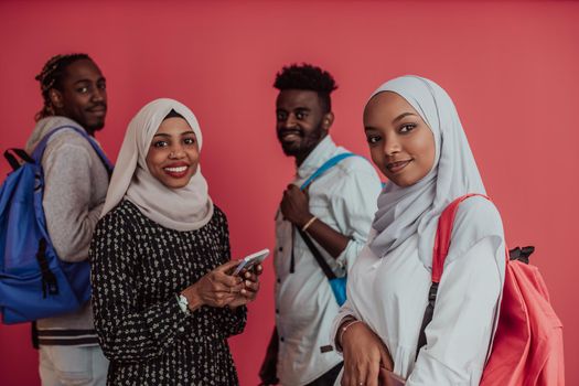 A group of African Muslim students with backpacks posing on a pink background. the concept of school education. High-quality photo