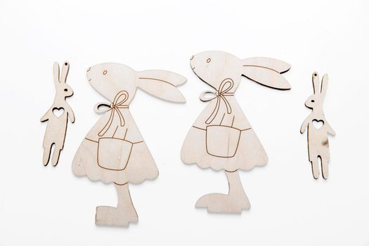 Frame for text. Wooden plywood figures of hares of different sizes, s on a white background