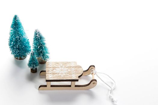 Wooden sleigh with decorative Christmas fir tree on white background. Christmas holidays. Copyspace. Place for text. Card
