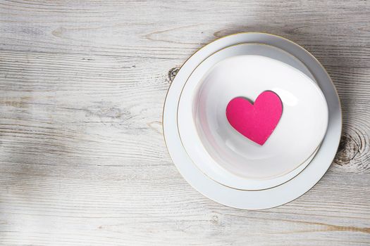 Red wooden hearts in a ceramic bowl filled with paper. Place for your text