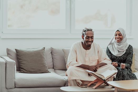 African Muslim couple at home in Ramadan reading Quran holly Islam book. High-quality photo