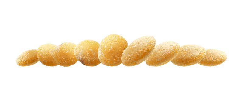 Yellow lentils levitate on a white background.