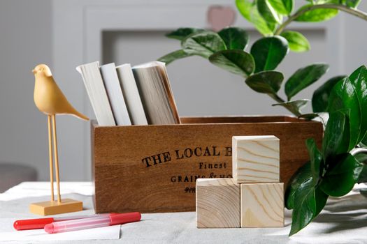 Wooden container with books, three cubes on the table against the background of a white fireplace. Place for text. Valentine's Day