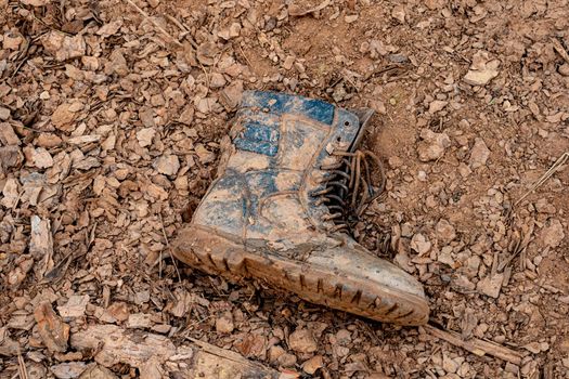 one soldier's boot in the mud. dirty boots on the ground. Losses in battle.