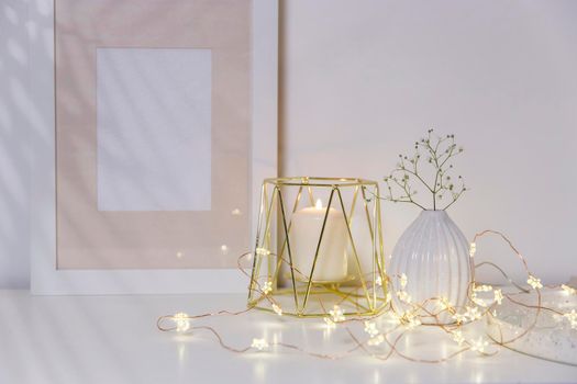 Two unopened hyacinths in a glass vase with artificial ice. Interior view in modern scandinavian style with painting canvas or poster on the wall. Living room, chest of drawers with vases.